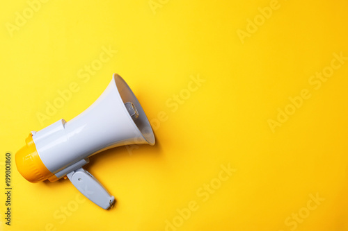 Electronic megaphone on color background