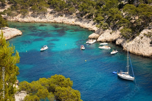Yachts in a narrow bay with blue water.
