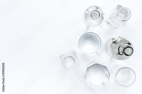 Drinks on the table. Pure water in jar and glasses on white background top view space for text