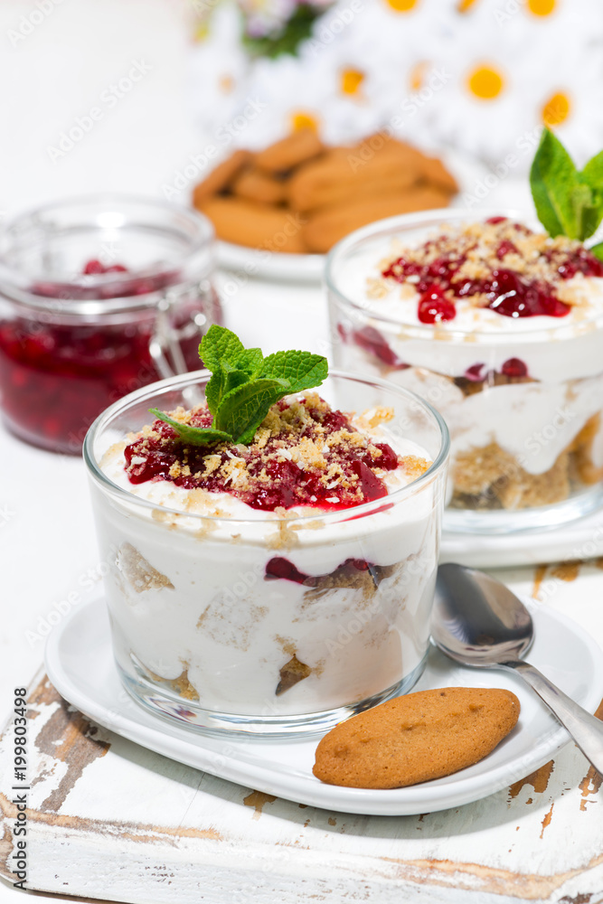 dessert in a glass with biscuits, cream and jam, vertical closeup dessert in a glass with biscuits, cream and jam, vertical closeup