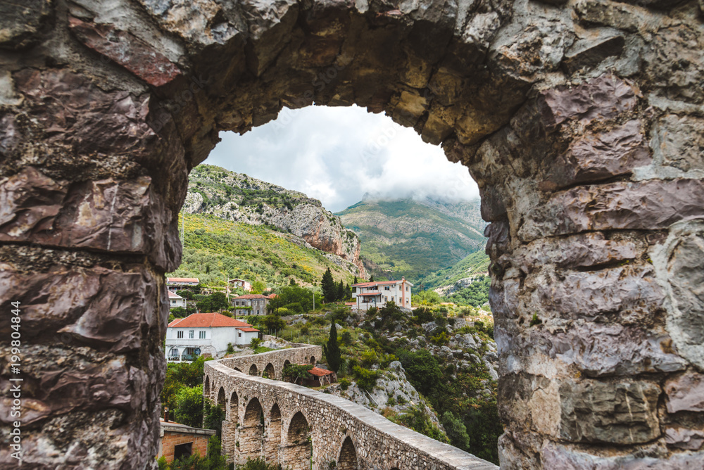 Rocks, ancient stone aqueduct and fortress wall of Old Bar town, Montenegro. Stari Bar - ruined medieval city on Adriatic coast, Unesco World Heritage Site.