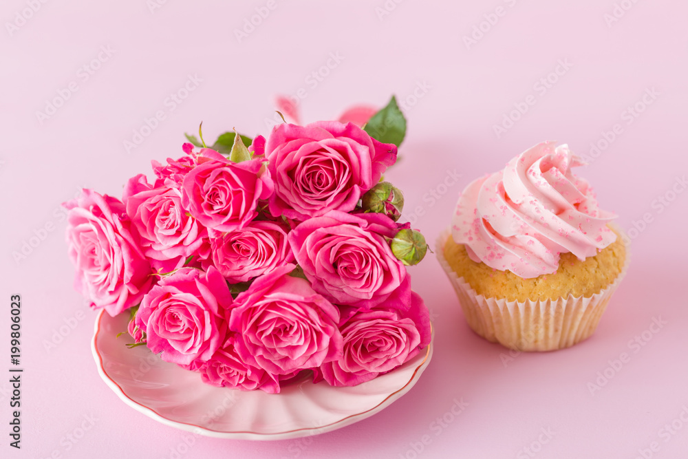 Cupcake with pink cream decoration and roses on pink pastel background. Cupcake with pink cream decoration and roses on pink pastel background.