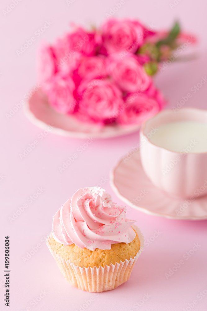 Cupcake with pink cream decoration and roses on pink pastel background. Cupcake with pink cream decoration and roses on pink pastel background.