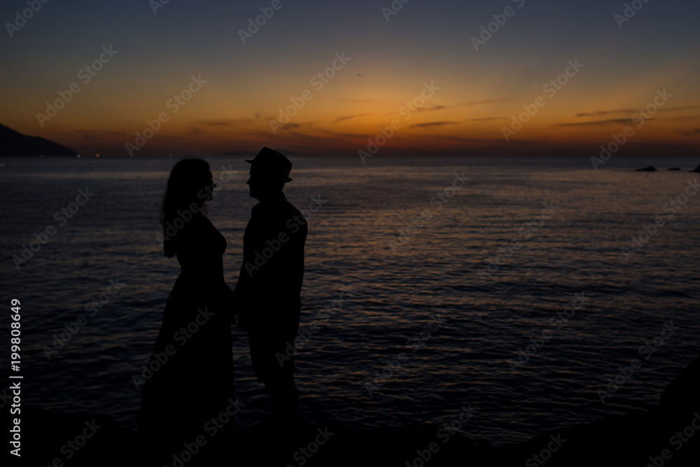 silhouettes of a couple holding hands at sunrise