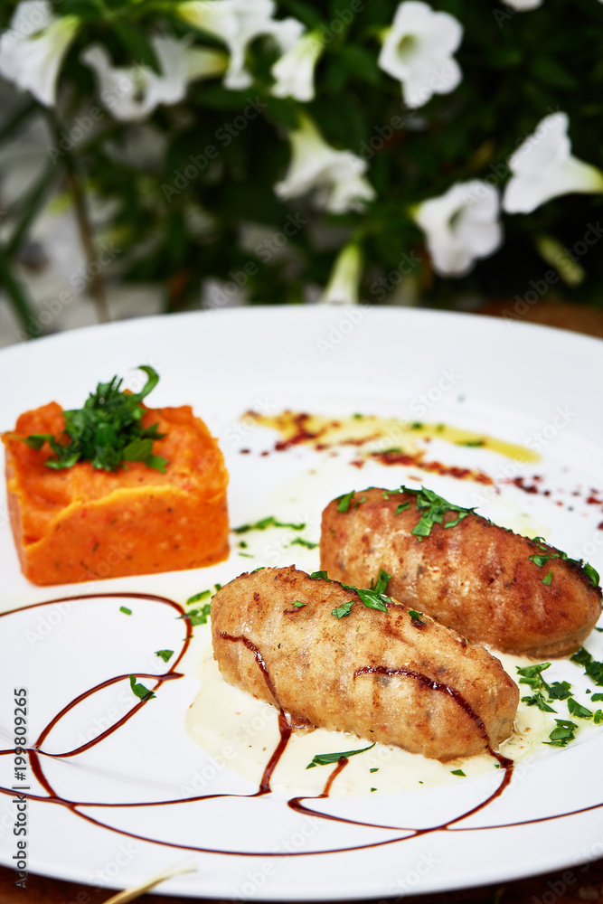 Delicious menu dish meat cutlet with carrot pie on white plate and wooden table Delicious menu dish meat cutlet with carrot pie on white plate and wooden table