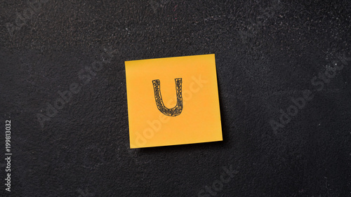 Sticky note with letter "U" on the blackboard