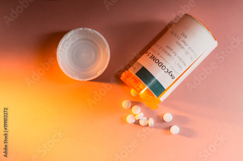 Oxycodone Prescription Bottle with Pills Spilling Out. photo