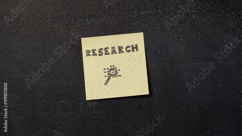 Sticky note with Research word on the blackboard