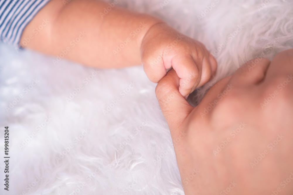 hand the sleeping baby in the hand of mother close-up. Extreme closeup of a baby's hand in mother's finger. Close-up of baby's hand holding mother's finger. tenderness. hand the sleeping baby in the hand of mother close-up. Extreme closeup of a baby's hand in mother's finger. Close-up of baby's hand holding mother's finger. tenderness.