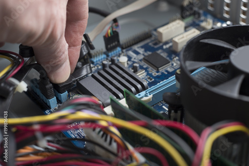 the hand of a computer engineer connect the cable, close-up