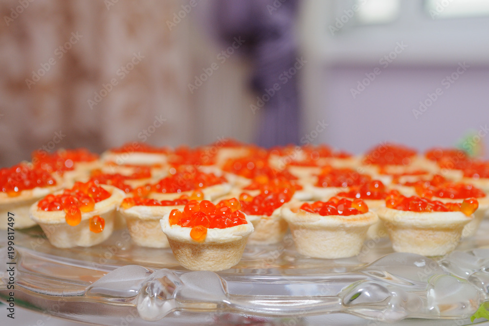 Appetizer of red caviar in tartlets on a glass dish. Appetizer of red caviar in tartlets on a glass dish.
