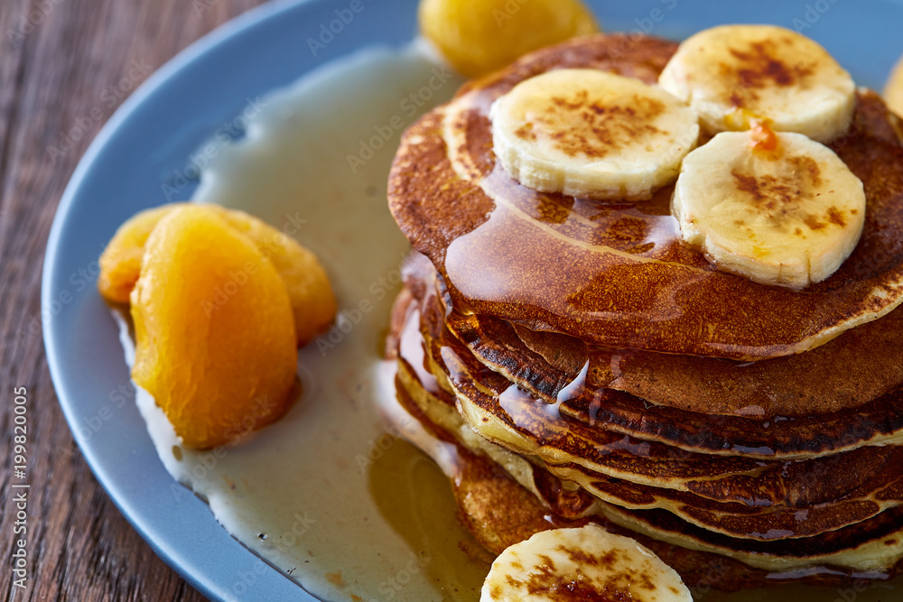 Pile of homemade pancakes with honey and walnuts on rustic wooden background, selective focus Pile of homemade pancakes with honey and walnuts on rustic wooden background, selective focus