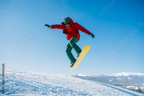 Snowboarder makes a jump on speed slope