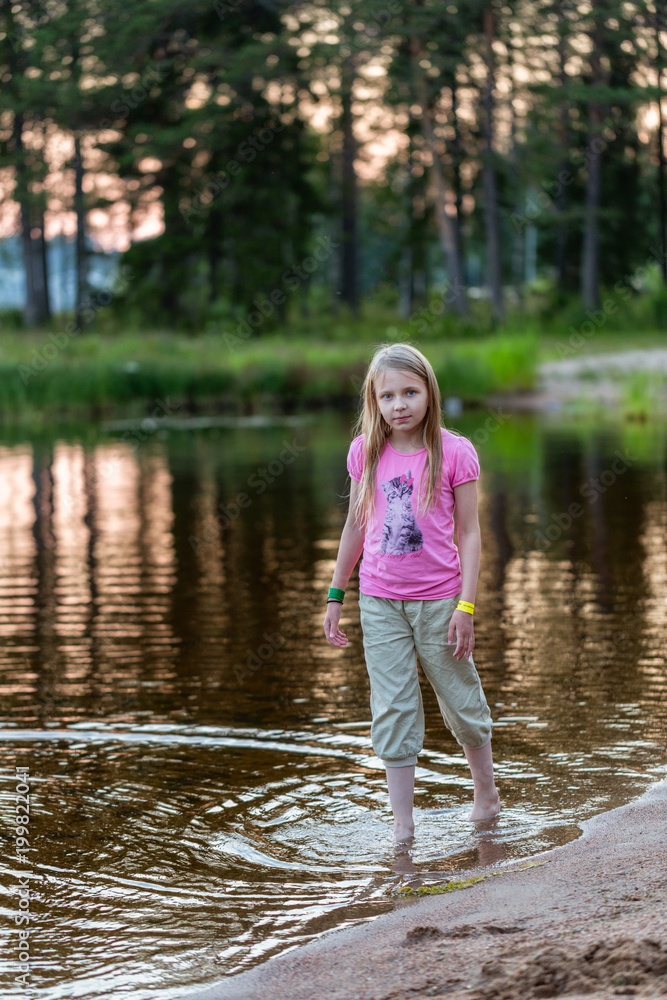 Young girl in the evening on the lake Young girl in the evening on the lake