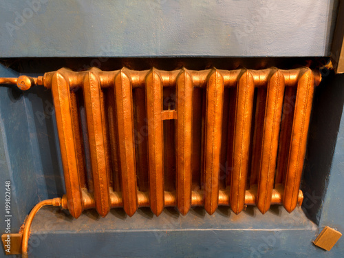 Copper heating radiator with blue wall background