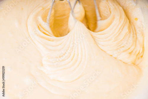 woman kneads the dough with an electric mixer
