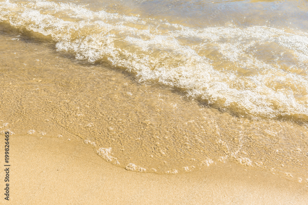 Soft wave on a sandy beach - close-up, top view Soft wave on a sandy beach - close-up, top view