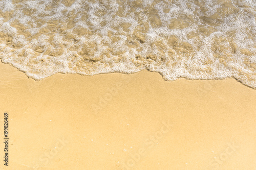Soft wave on a sandy beach - close-up, top view