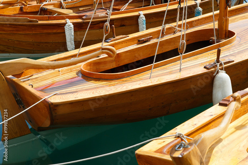 Fragments of wooden sailing yachts moored at the waterfront.