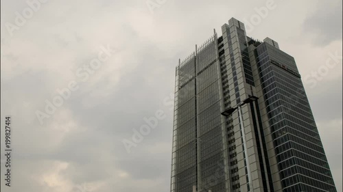 Turin, Italy, Piedmont. April 8 2018. The skyscraper, headquarters, of the Intesa - SanPaolo bank. Time lapse in which the gray and rain clouds are seen to flow. The signal lights flash. photo