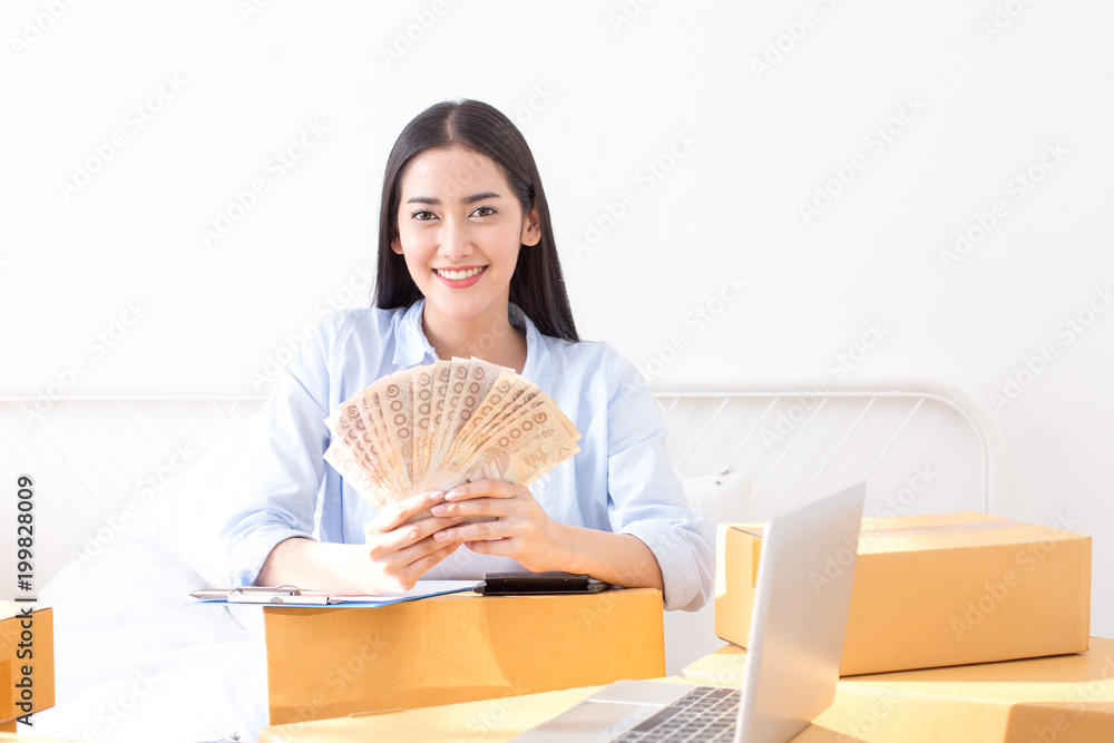 Young Asian Woman Working at home, Young Owner Woman Start up for Business Online. People with online shopping SME entrepreneur or freelance working concept. Young Asian Woman Working at home, Young Owner Woman Start up for Business Online. People with online shopping SME entrepreneur or freelance working concept.