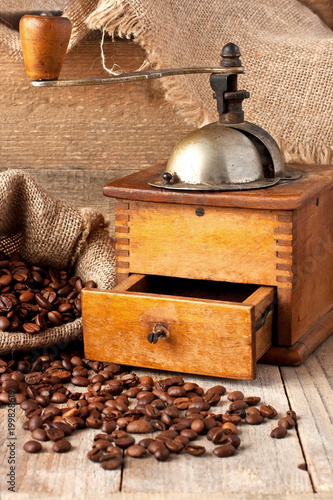 Coffee grinder and coffee beans on wooden background