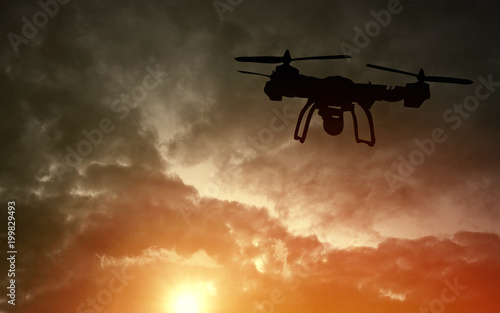 Innovation concept. Silhouette of drone flying on sunset. Heavy lift drone photographing