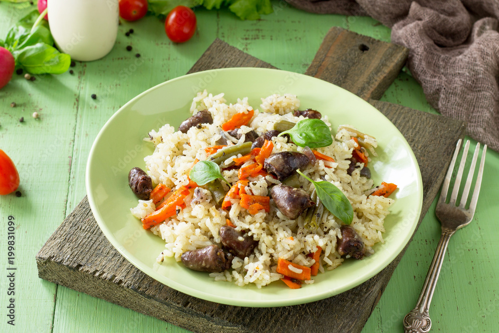 Rice with vegetables and chicken hearts on a gray stone table. Healthy proper nutrition. Rice with vegetables and chicken hearts on a gray stone table. Healthy proper nutrition.