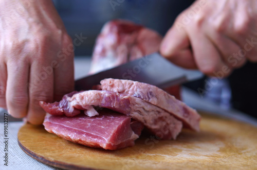 A woman is cutting meat