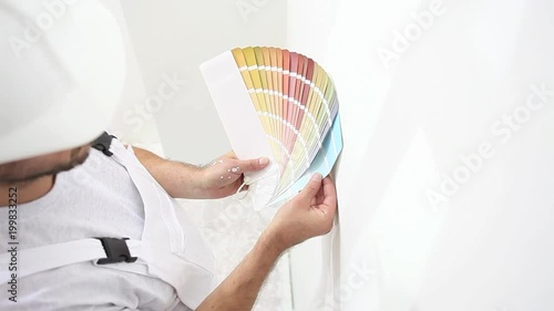 painter man at work choice color with swatches samples, wall painting concept, white copy space background