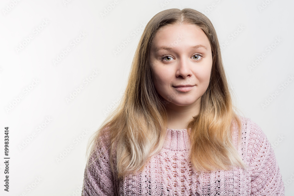 Portrait of a young beautiful blonde woman with absolutely not make up in pink knitted sweater against white background. Natural beauty concept Portrait of a young beautiful blonde woman with absolutely not make up in pink knitted sweater against white background. Natural beauty concept