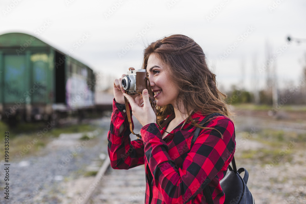 young beautiful woman wearing casual clothes taking a picture with a vintage camera. Outdoors city background. Lifestyle. young beautiful woman wearing casual clothes taking a picture with a vintage camera. Outdoors city background. Lifestyle.