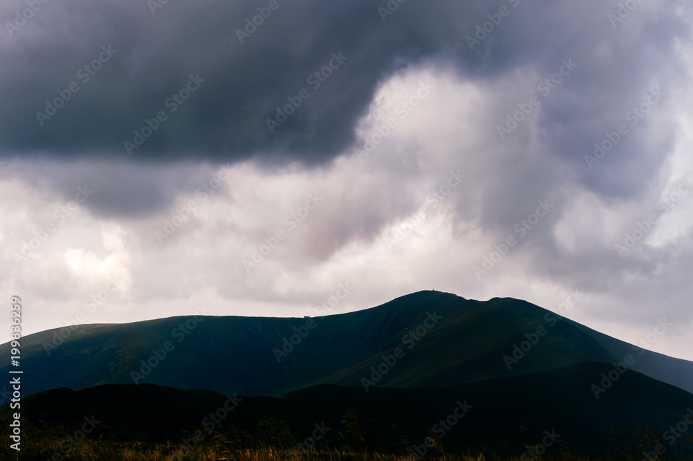 Storm rainy clouds above mountains. Apocalypse fantasy fabulous sky. Beautiful windy dramatic cloudscape at nature. Picturesque scenic view outdoor. Travel in wild territory. Discover rocky hills.