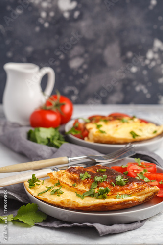 Delicious bright egg omelet with cheese and vegetables. Breakfast food concept, dark background