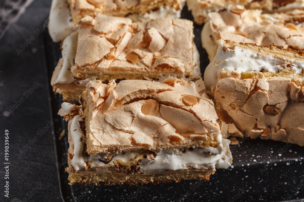 Sliced cake with meringue and whipped cream, dark background Sliced cake with meringue and whipped cream, dark background