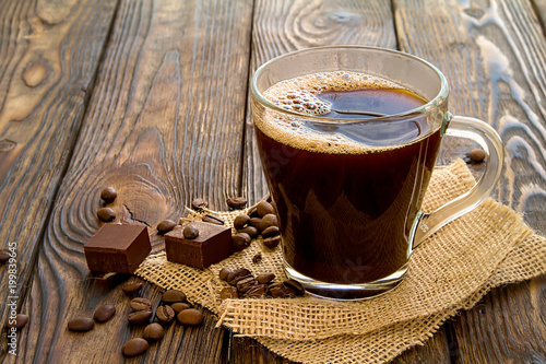 espresso coffee and chocolate with scattered coffee beans on old wooden dark table