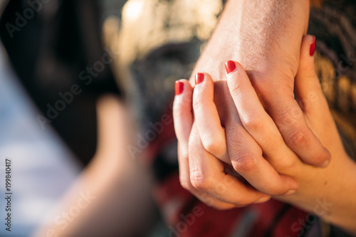 a couple holding each other's hands, red nail
