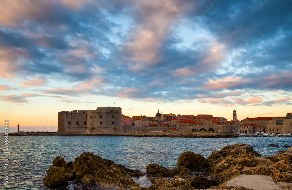 Sunrise in Dubrovnik, a landscape overlooking the old town and large stones in the foreground, Croatia