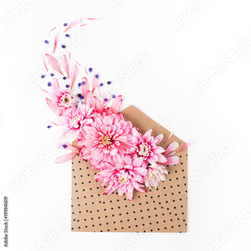 Beautiful floral arrangements. Pink chrysanthemums with envelope on white background. Flat lay, top view. © igishevamaria