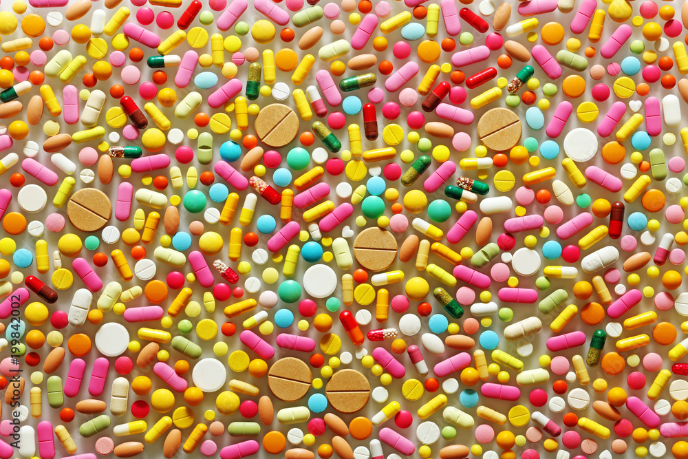 A lot of colorful pills on a grey background A lot of colorful pills on a grey background