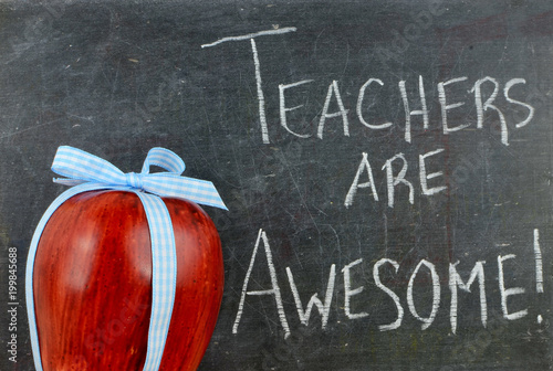 Teacher appreciation image of a red apple tied up with a cute blue ribbon in front of a worn blackboard with a message written in white chalk