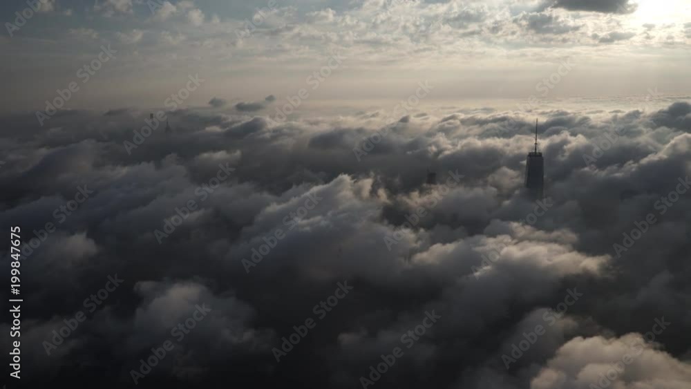 New York City aerial view of Manhattan in the morning, covered by low level clouds, with One World Trade Center and the Empire State building poking out. New York City aerial view of Manhattan in the morning, covered by low level clouds, with One World Trade Center and the Empire State building poking out.