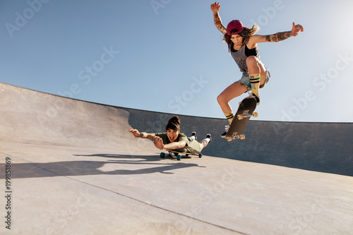Obraz na płótnie Female skaters doing stunts at skate park