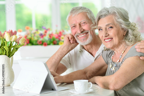 portrait of happy beautiful senior couple using tablet