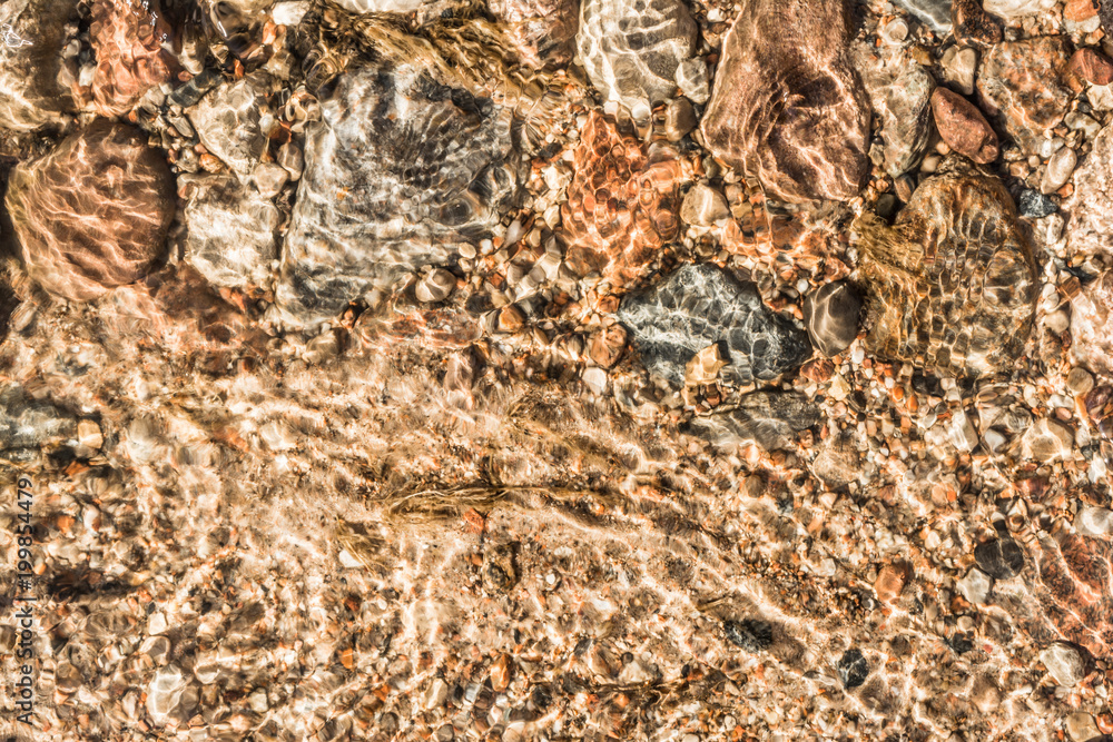 sand, stones of different size and leaves under the water in the sunlight, abstract background sand, stones of different size and leaves under the water in the sunlight, abstract background