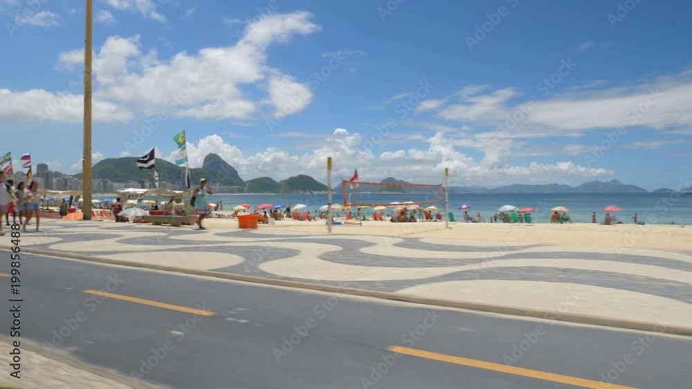 Copacabana Beach on Sunny Day, Rio De Janeiro, Brazil. Driving along the famous mosaic walkway. Slow motion Copacabana Beach on Sunny Day, Rio De Janeiro, Brazil. Driving along the famous mosaic walkway. Slow motion