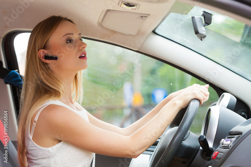 woman driving car with headset