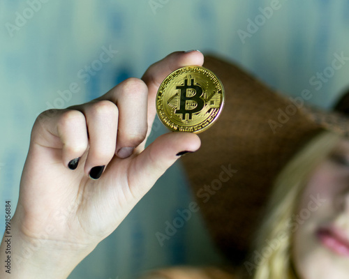 The girl is holding bitcoin on her outstretched hand.
