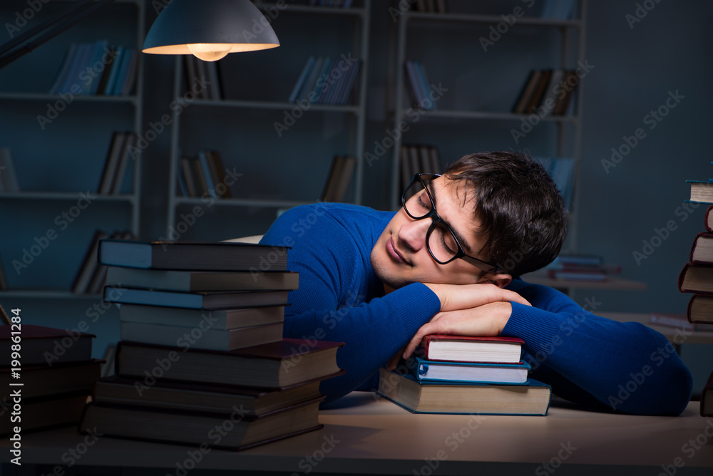 Student preparing for exams late at night in library Student preparing for exams late at night in library
