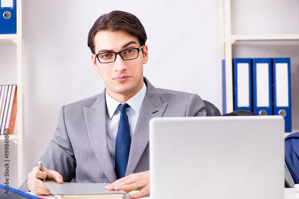 Young handsome businessman employee working in office at desk